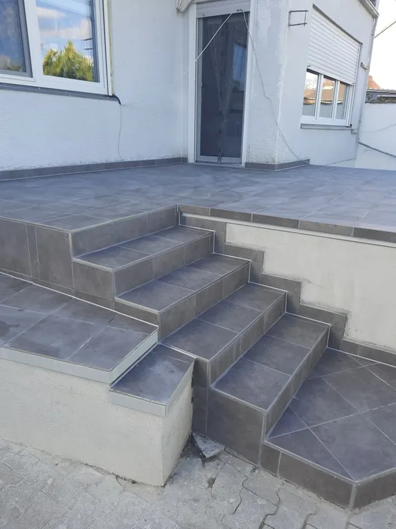 Fertige Terrasse mit gefliesten Stufen in Anthrazit