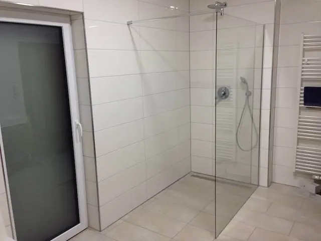 Walk-in-Dusche mit Glasabtrennung und hellen Großformatfliesen – Fliesen Berisha Neulußheim